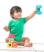 Baby boy sitting playing with building blocks