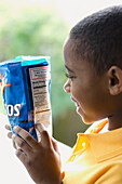 Boy reading ingredients on the back of savoury snacks