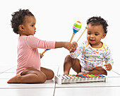 Twin boy and girl playing with xylophones and maracas