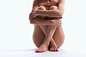 Naked women sitting with her legs crossed