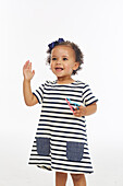 Little girl in stripey dress playing