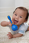 Baby boy holding plastic rattle