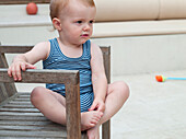 Blonde toddler sitting on chair