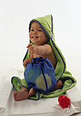 Boy wrapped in a towel holding a washbag