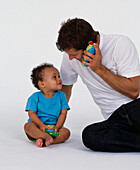 Father and son playing with toy telephones