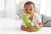 Boy playing with knitted dinosaur toy