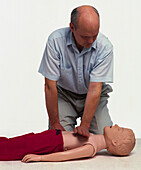 Demonstrating chest compressions on dummy child