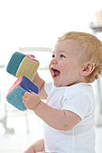 Baby boy holding knitted building blocks