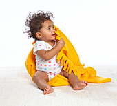 Baby girl holding yellow blanket
