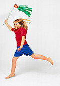 Girl running and holding a green streamer