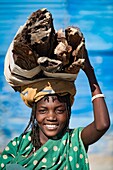 Girl from the Zemba tribe carrying firewood