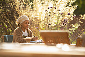 Woman working at cafe table in garden