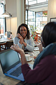 Mother and daughter talking in cafe