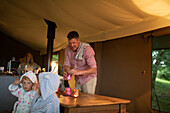 Family lighting candles at table in yurt cabin