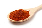 Ground paprika on a wooden spoon