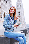 Woman sitting down holding smartphone