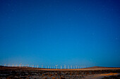 Windmills in a desert at night