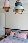 Pendant lights above bed with bed linen in pink and blue