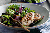 Gegrillte Hähnchenbrust mit gemischtem Blattsalat, schwarzen Linsen und Oliven