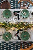 Festive table setting with green plates and white tablecloth