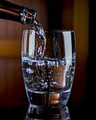 Sprudelwasser in ein Glas gießen