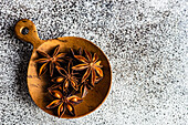 anise star spice for baking in wooden spoon on concrete table