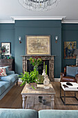 Wooden table and seating in front of fireplace in the living room with a blue wall