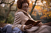 Serene young woman reading in park