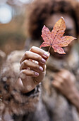 Woman holding autumn leaf