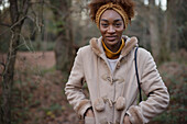 Happy young woman in coat in autumn woods