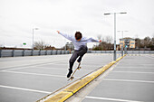 Teenage boys skateboarding in parking lot