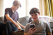 Teenage boys with smartphone studying at home