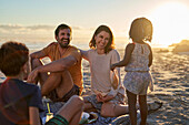 Happy family eating on sunny summer beach