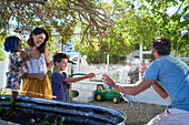 Happy family playing with hose in backyard