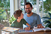 Father and son reading and assembling puzzle at home