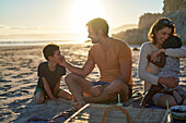 Happy family enjoying picnic on summer beach