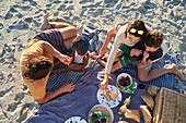 Family enjoying picnic lunch on summer beach