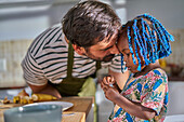 Affectionate father and cute toddler daughter in kitchen