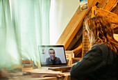 Woman video conferencing with colleague