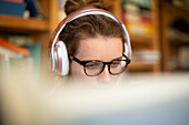 Focused woman with headphones working from home