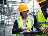 Architects with digital tablet at construction site