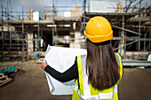 Architect reviewing blueprints at construction site