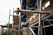 Construction worker climbing scaffolding