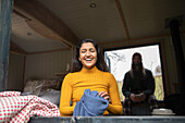 Happy young woman laughing in tiny cabin rental