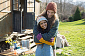 Carefree young couple hugging outside sunny cabin rental