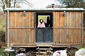 Carefree young woman in tiny cabin rental window