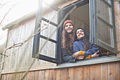 Happy young couple in tiny cabin rental window