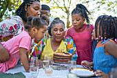 Multigenerational family blowing out birthday candles