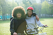 Happy teen couple hugging on bicycles in park