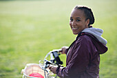 Happy young woman riding bike in park